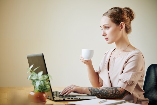 仕事をしながらコーヒーを飲む女性実業家