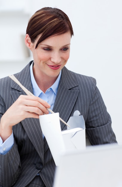 Businesswoman eating chinese food with chopstick 