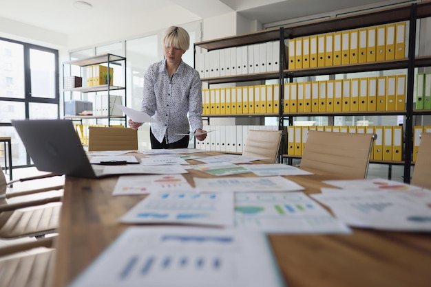 Businesswoman examines papers in empty company office