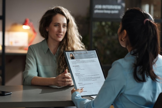 Photo businesswoman examining resume of candidate