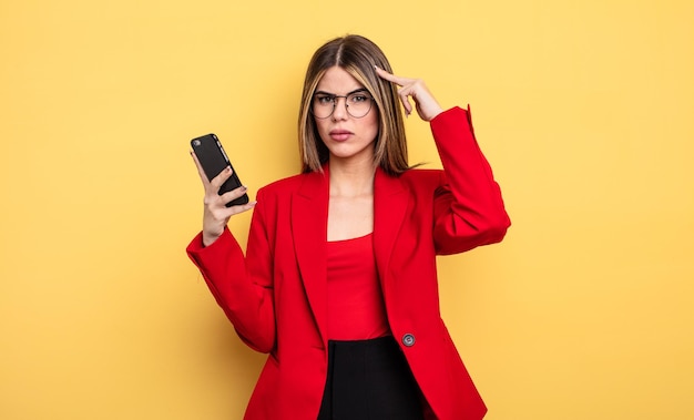 Businesswoman feeling confused and puzzled showing you are\
insane smartphone concept
