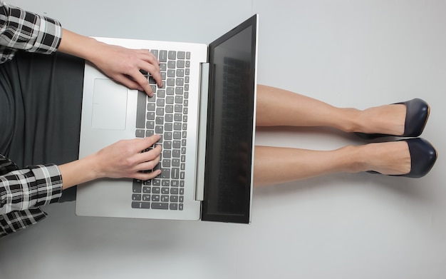 Деловая женщина в формальной одежде, используя ноутбук, сидя