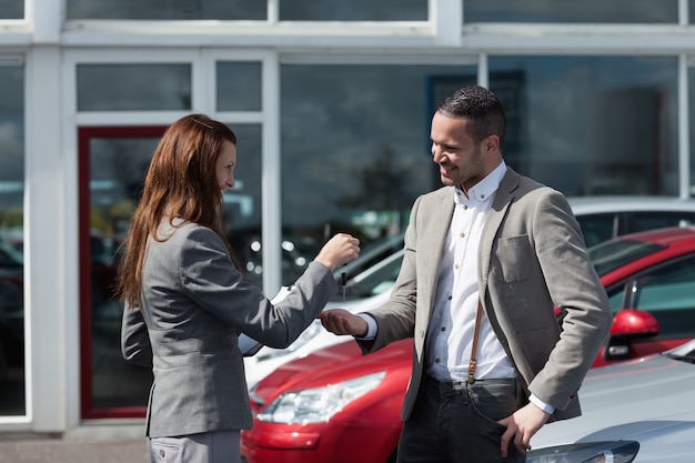 Photo businesswoman giving car keys to a man