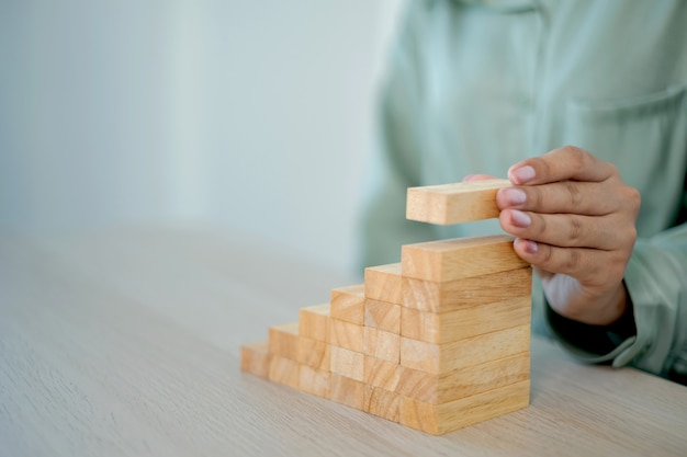 Businesswoman hand holding blocks wood game, Concept Risk of management and strategy plan, growth business success process and team work.