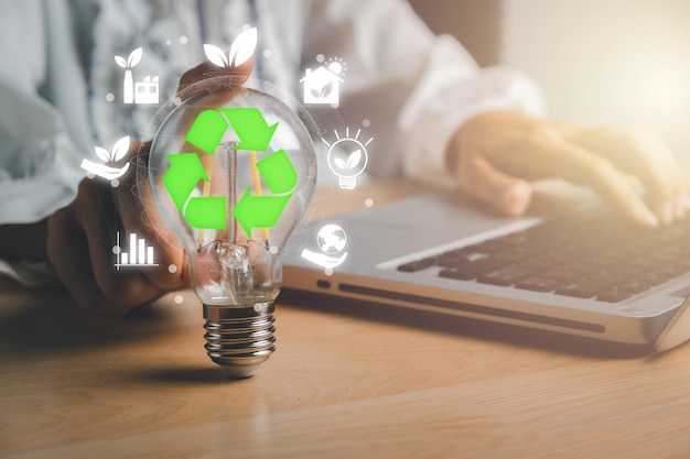 Businesswoman hand holding light bulb with esg icon on virtual screen ESG Environmental social and corporate governance concept