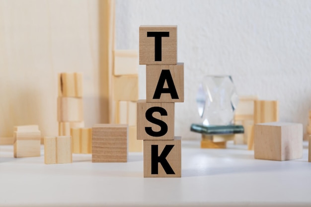 사진 task 비즈니스 단어와 함께 나무 큐브 블록을 들고 있는 사업가