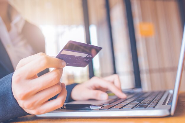 businesswoman hand holds a blue credit card.