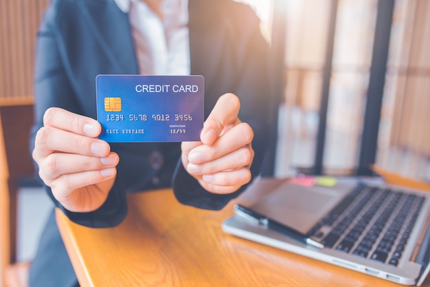 businesswoman hand holds a blue credit card.