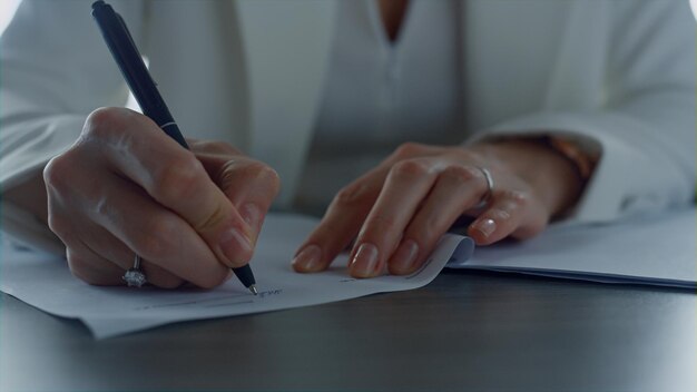 Businesswoman hand signing report in office closeup Financial manager approving