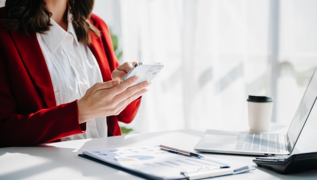 Businesswoman hand using smart phone tablet payments and holding credit card online shopping omni channel digital tablet docking keyboard computer at office in sun lightxAxA