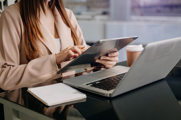 Businesswoman hand using smart phone, tablet payments and holding credit card online shopping, omni channel, digital tablet docking keyboard computer at office