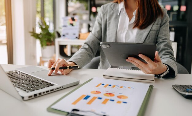 Foto donna d'affari che lavora a mano con i media di marketing digitale su schermo virtuale con telefono cellulare e computer moderno con diagramma di icone vr in ufficio alla luce del mattino