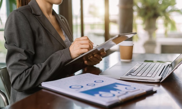 Businesswoman hand working with new modern computer and writing on the notepad strategy diagram as concept