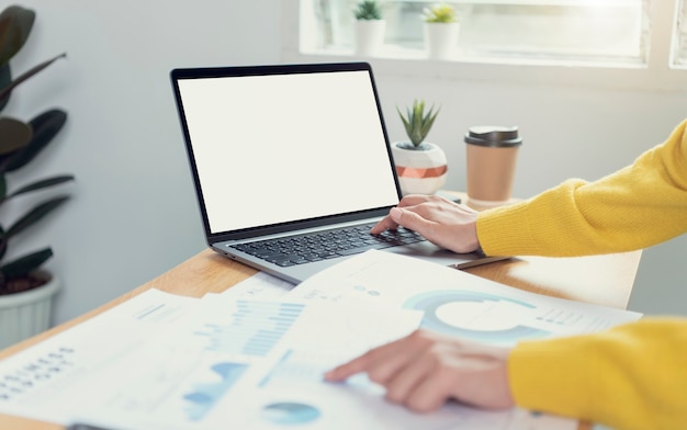 Businesswoman hands using laptop with blank screen. Mock-up of computer monitor. Copyspace ready for design or text.