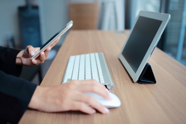 Businesswoman hands using table and cell phone