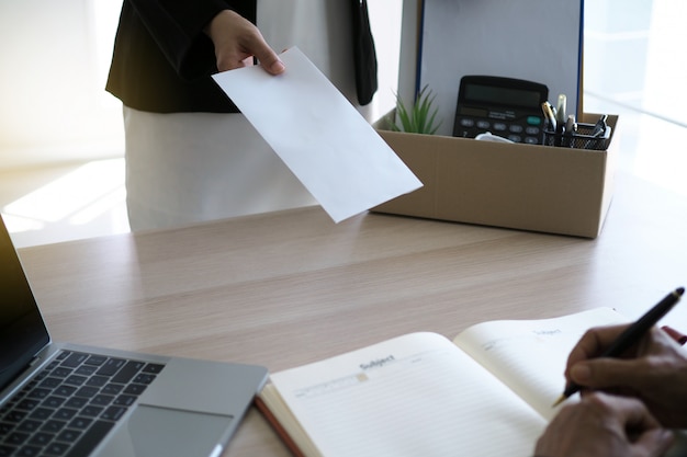 Businesswoman have boxes for personal use and are sending resignation letters to executives