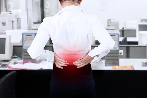 Photo businesswoman having back pain at office