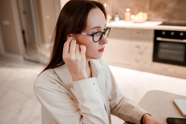 Businesswoman in headphones wearing casual clothes working at home office on laptop Young happy female student studying in online university