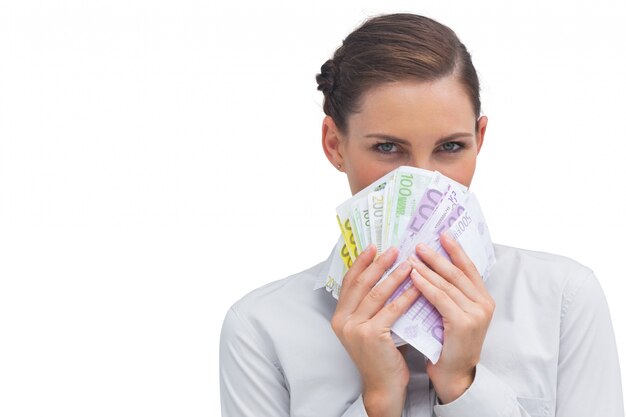 Businesswoman hiding behind money 