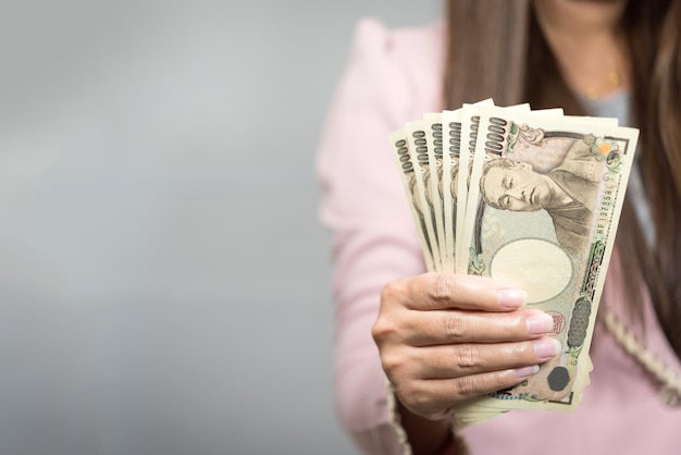 Photo businesswoman holding 10,000 japanese yen  money in hand