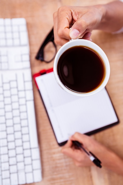 Businesswoman holding black coffee cup