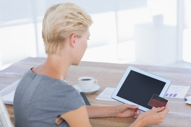 Businesswoman holding credit card and tablet 