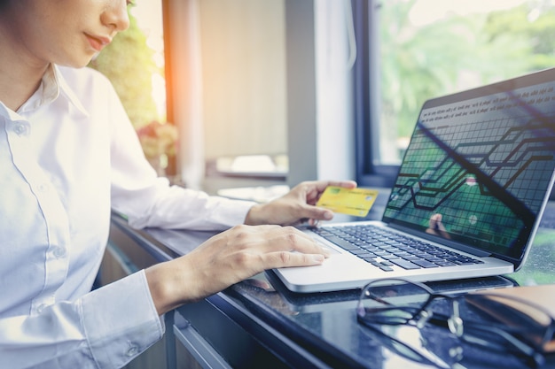 Businesswoman holding credit card and using laptop computer. Online shopping . Selected focus