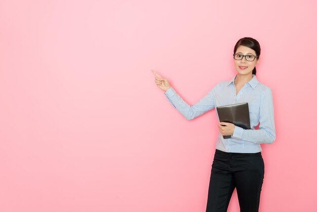 businesswoman holding a digital tablet and showing presentation gesture to blank copy space