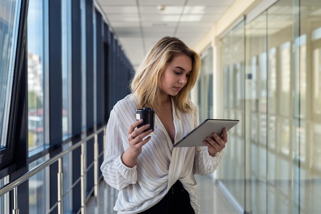 businesswoman holding digital tablet standing in corridor