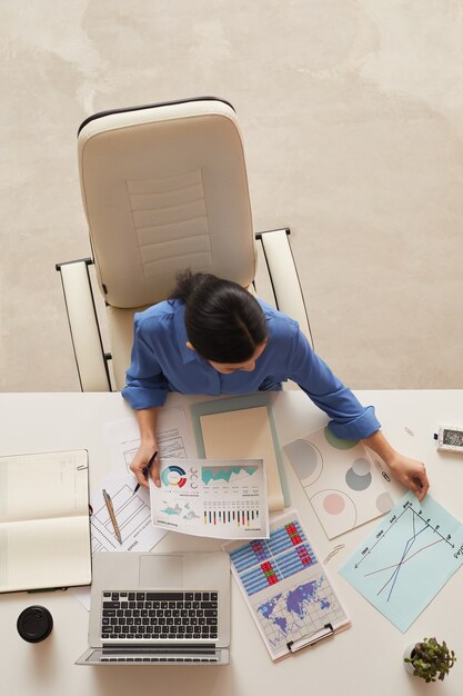 businesswoman holding document while sitting at table, copy space