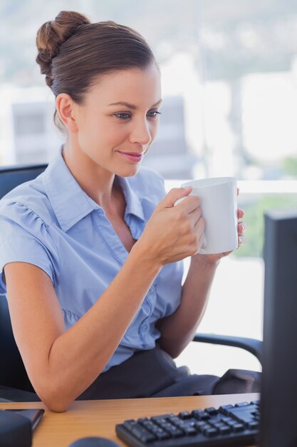 Businesswoman holding her mug and smiling 