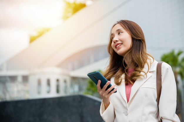 businesswoman holding laptop and check message on mobile smart phone