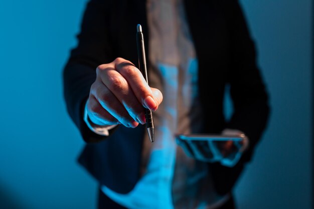 Businesswoman Holding Mobile Phone And Pointing With Pen On Important Messages Standing Woman In Suit Having Cellphone And Presenting Crutial Informations