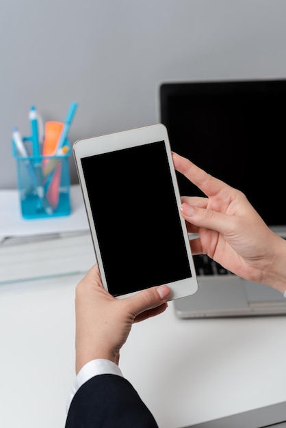 Businesswoman Holding Mobile Phone And With Important Messages Sitting Woman In Suit Having Cellphone And Presenting Crutial Informations New Ideas Presented On Tablet