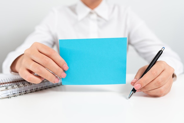 Businesswoman Holding Note With Important Message And Pointing With Pen Woman Presenting Crutial Information On Paper Executive Showing Critical Announcement