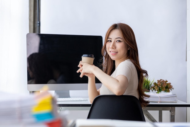 Businesswoman holding a paper cup of coffee a young businesswoman and a young executive founded a startup that has consistently made high profits Concept of young businesswoman and startup company