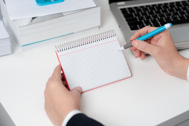 Businesswoman holding pen and note with important message with one hand woman having notebook