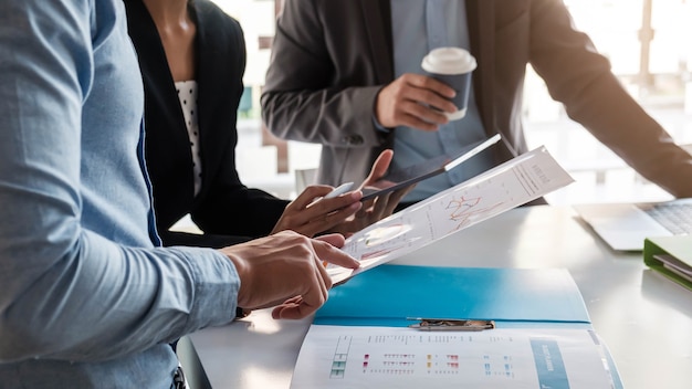 Businesswoman holding pens and holding graph paper are meeting to plan sales to meet targets set in next year.
