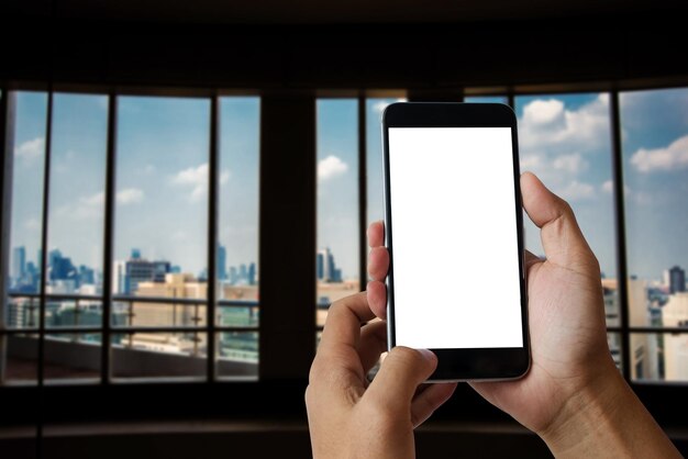 Businesswoman holding smartphone in her office roomxA