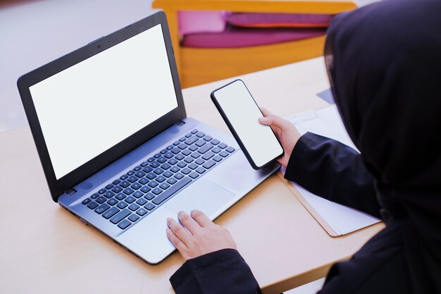 Businesswoman holding and touch the mobile phone in the office