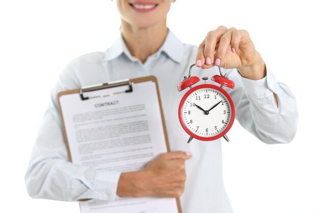 Businesswoman holds a contract and alarm clock for ten in morning signing and concluding