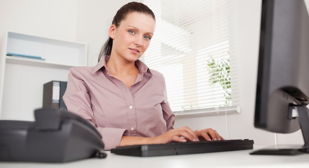 A businesswoman is typing on her keyboard