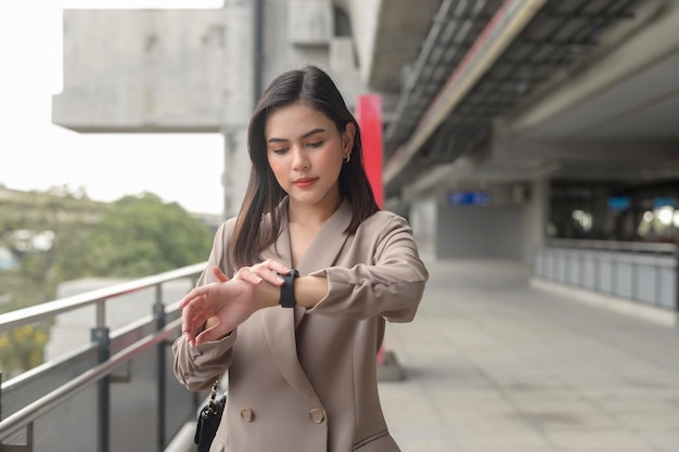 実業家は、近代的な都市のビジネス技術都市のライフスタイルの概念でスマートウォッチを使用しています