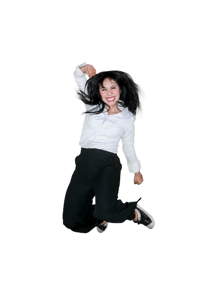 Businesswoman jumping in studio while smiling