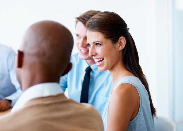 Photo businesswoman laugh and team in a meeting in the office in discussion and speaking about a funny joke collaboration teamwork and professional employees working on company project in the workplace