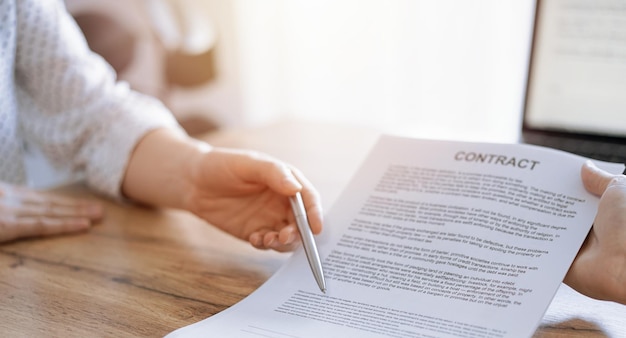 Businesswoman lawyer pointing into contract special points admitting something for colleague or client at the wooden desk in office Business people teamwork and partnership meeting concept
