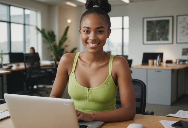 A businesswoman in a lime top working on her laptop in the office showing focus and drive