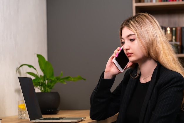 彼女の携帯電話で会話を聞いている実業家