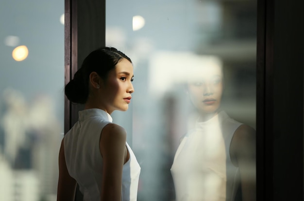 businesswoman looking away standing by window