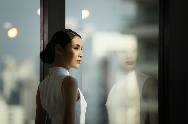 Photo 站在窗口旁邊的女商人